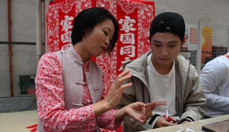 两岸同胞南宁共剪吉祥图案 非遗剪纸架起心灵契合桥的配图